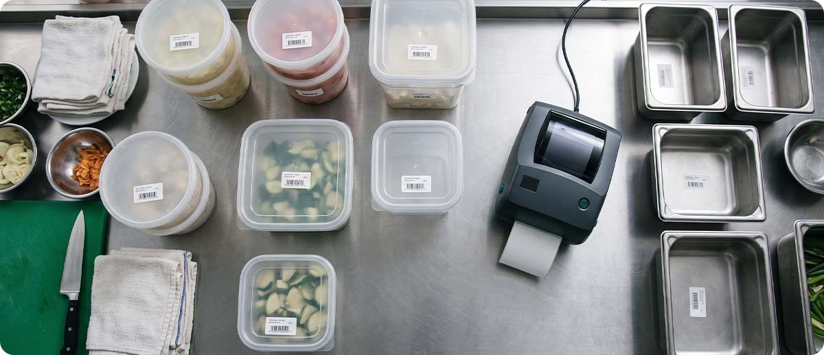 dissolvable labels Prep containers labeled with dissolvable date labels next to a desktop label printer